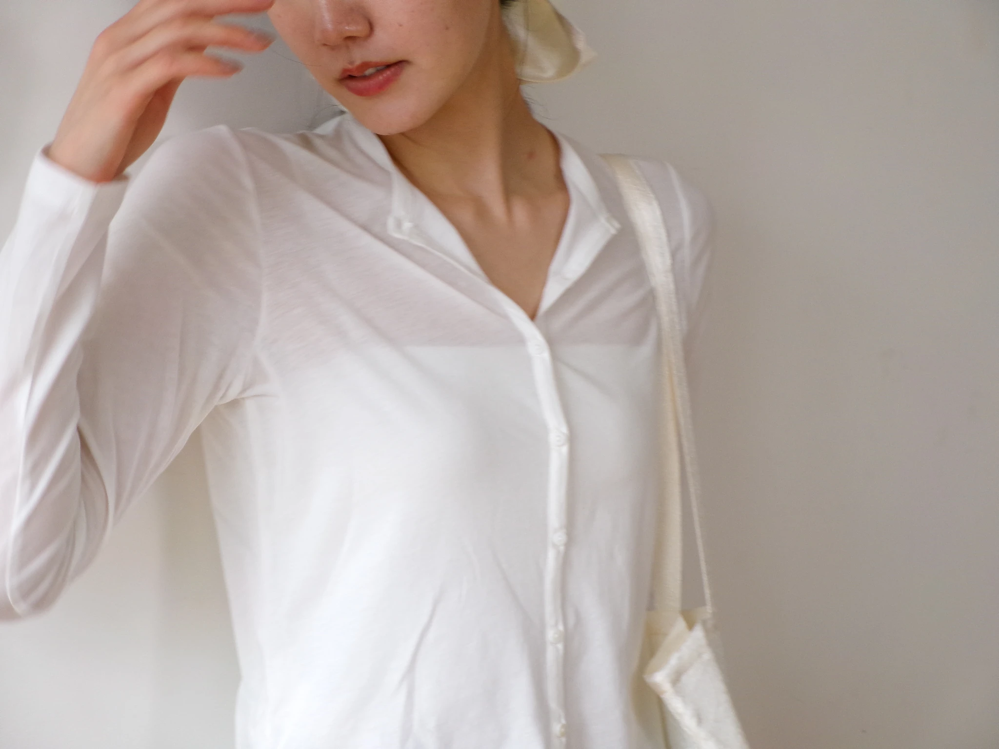 白色のsheer cotton cardiganを着た女性
