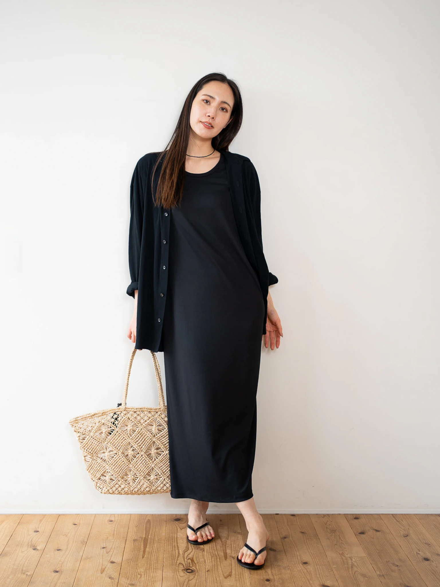 黒色のcut and sew shirtと黒のone-pieceを着る女性