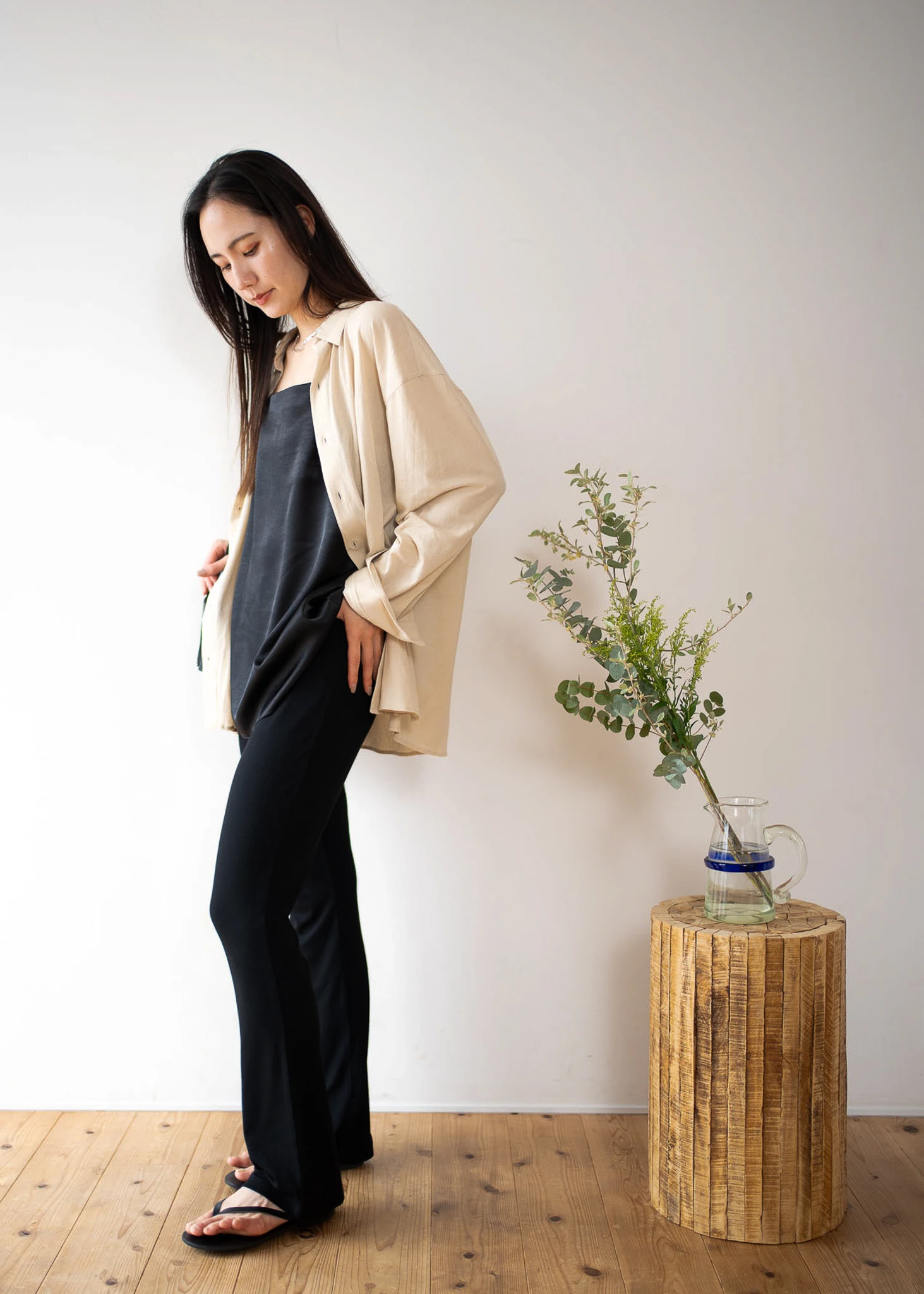 ベージュのcut and sew shirtとレーヨンリブフレアパンツを着る女性