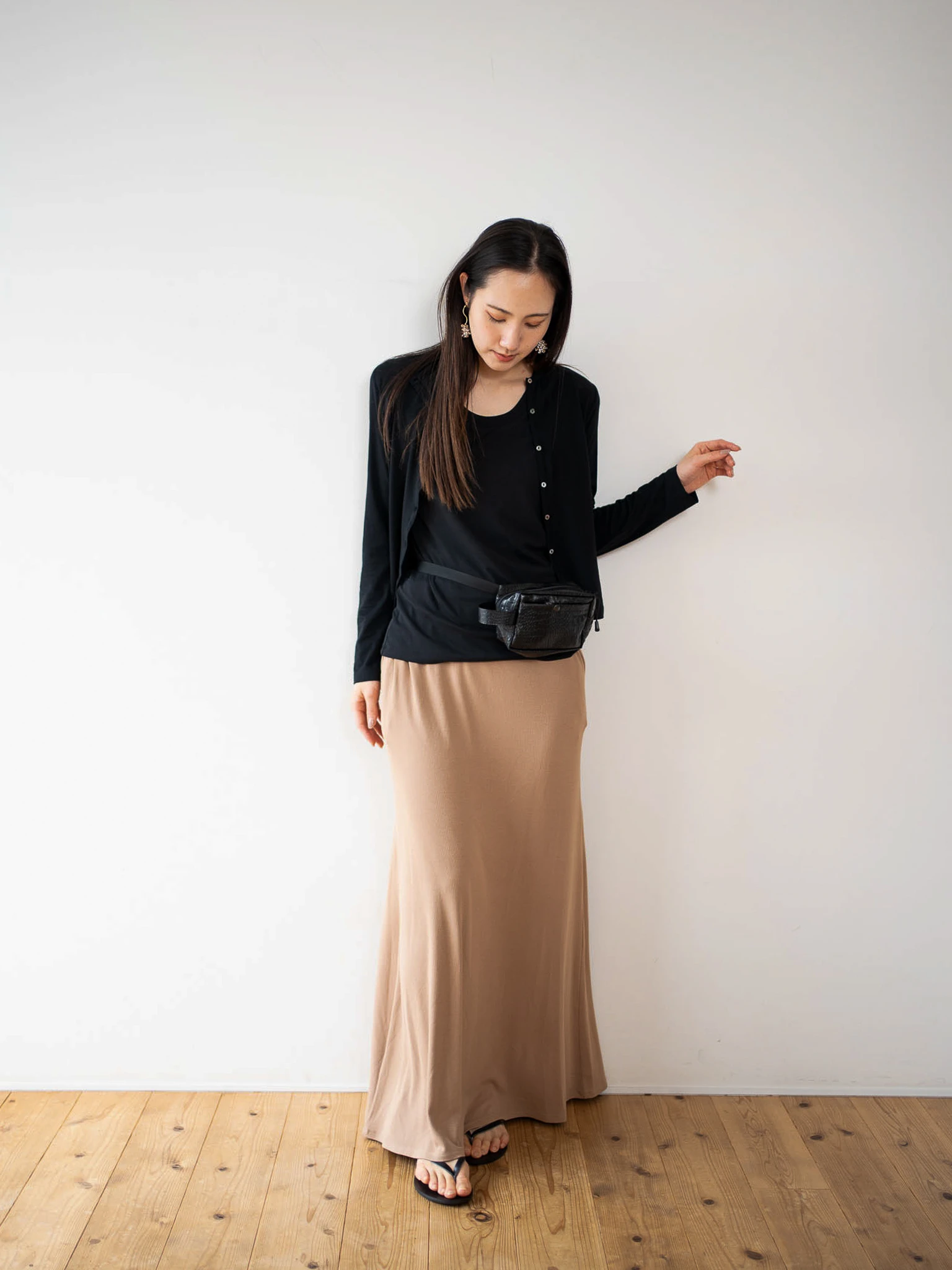 黒色のsheer cotton cardiganとレーヨンリブスカートをはいている女性